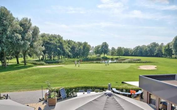 Uitzicht vanaf het terras van golfbaan Sluispolder op de green