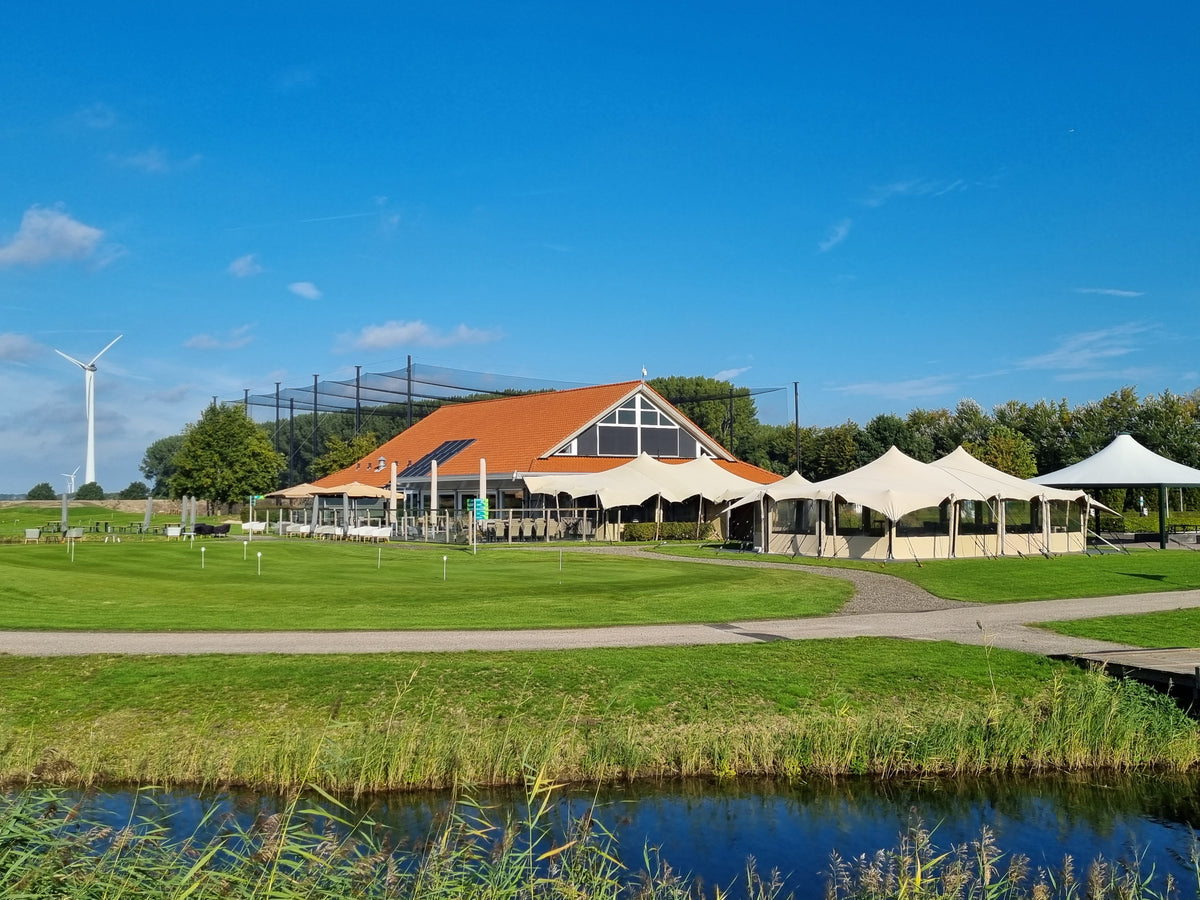 Clubhuis van Harderwold Golf & Events met terras en driving range